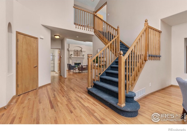 staircase featuring hardwood / wood-style flooring and a high ceiling