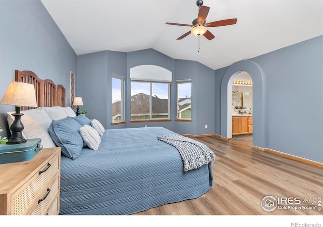 bedroom featuring vaulted ceiling, ceiling fan, hardwood / wood-style floors, and ensuite bath