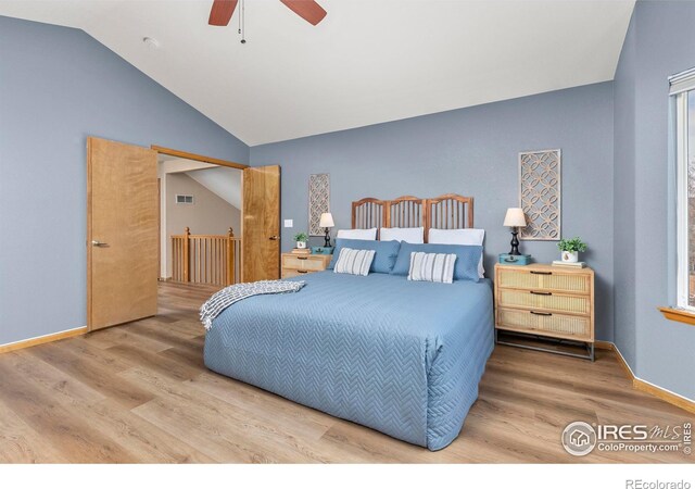 bedroom with ceiling fan, wood-type flooring, and lofted ceiling