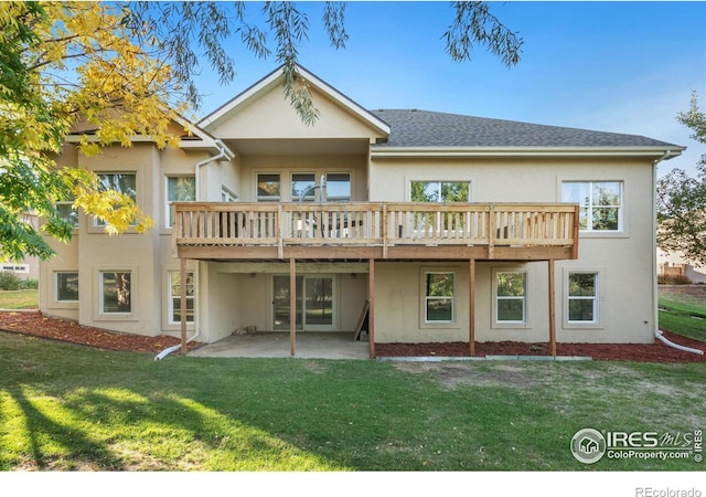 rear view of property featuring a patio area, a yard, and a wooden deck