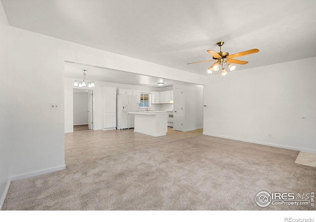 unfurnished living room with ceiling fan with notable chandelier and light colored carpet