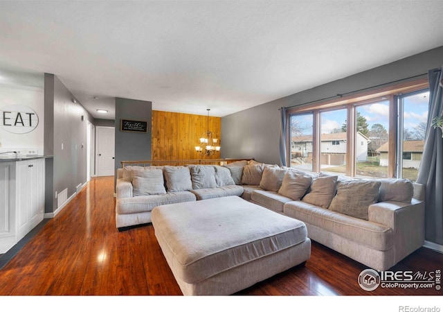 living room with dark hardwood / wood-style flooring and a notable chandelier