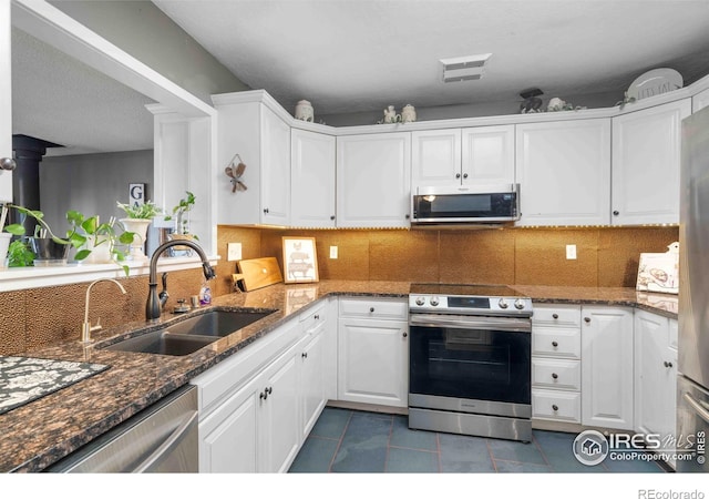 kitchen featuring dark stone countertops, sink, white cabinets, and stainless steel appliances