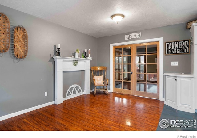 interior space featuring a fireplace, french doors, dark hardwood / wood-style floors, and a textured ceiling