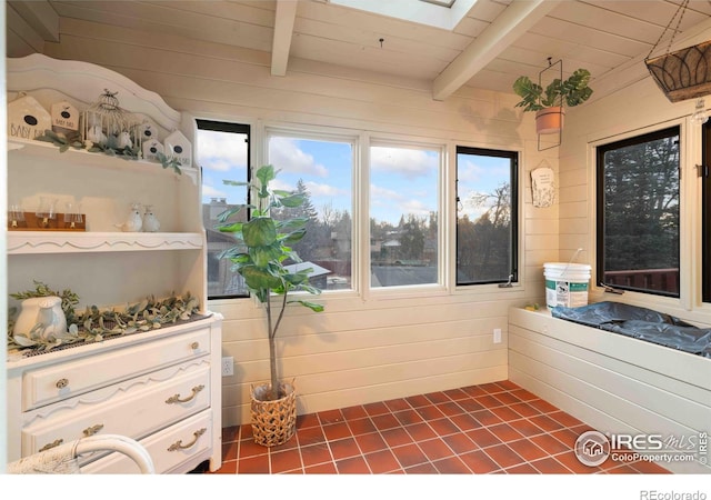 interior space with beam ceiling, a skylight, and wood ceiling