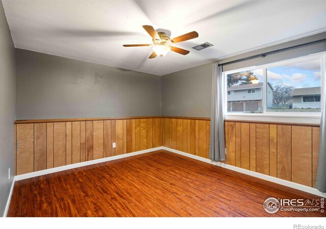 spare room with ceiling fan and wood-type flooring