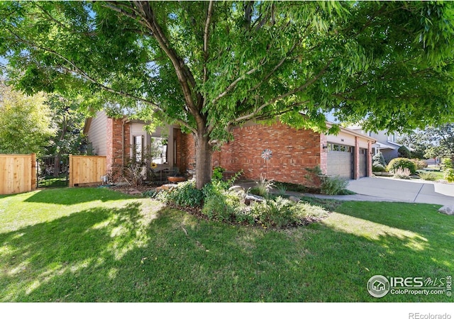 view of property hidden behind natural elements featuring a front yard and a garage