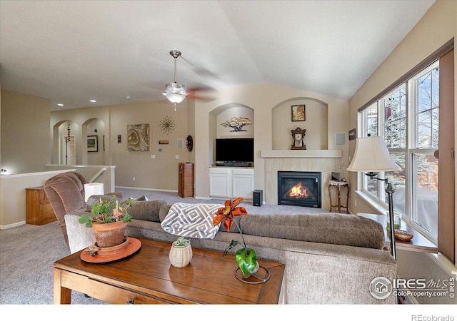 carpeted living room featuring ceiling fan, a fireplace, and lofted ceiling