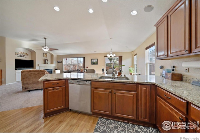 kitchen featuring light stone countertops, ceiling fan with notable chandelier, sink, dishwasher, and light hardwood / wood-style floors