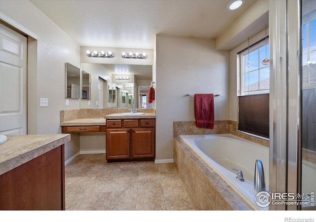 bathroom with a relaxing tiled tub and vanity