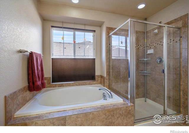 bathroom featuring shower with separate bathtub