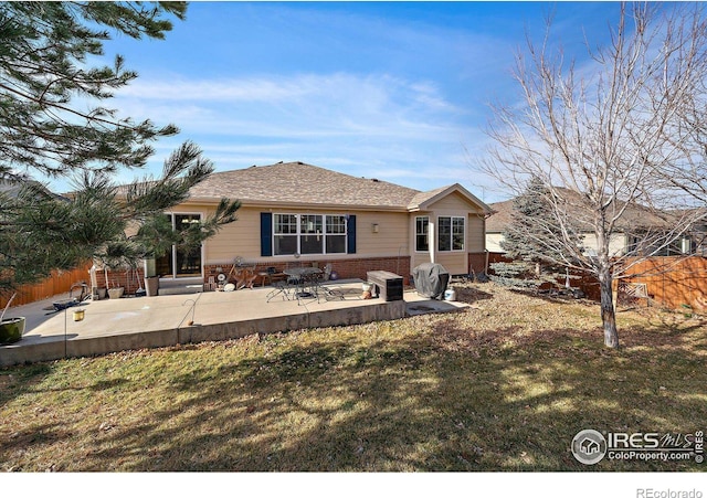 back of property with a lawn and a patio