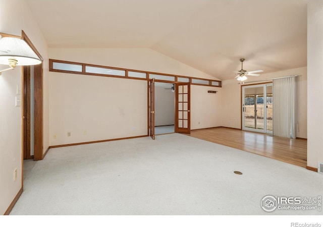 carpeted empty room with french doors, vaulted ceiling, and ceiling fan