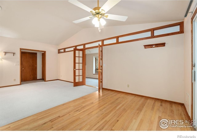 spare room with ceiling fan, vaulted ceiling, light hardwood / wood-style flooring, and french doors