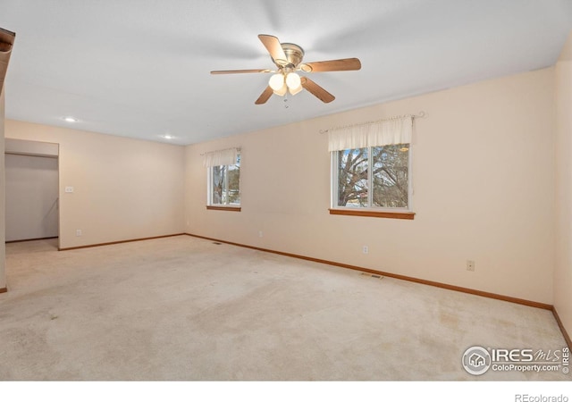 carpeted spare room with ceiling fan