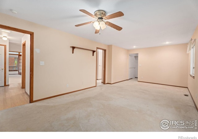 carpeted spare room featuring ceiling fan