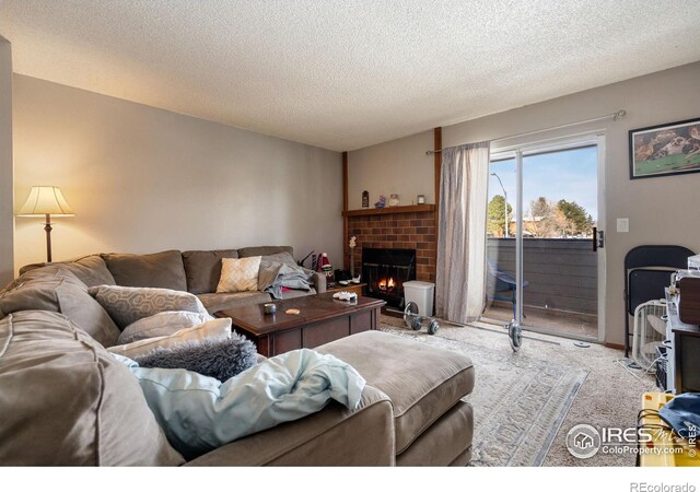 carpeted living room featuring a textured ceiling and a fireplace