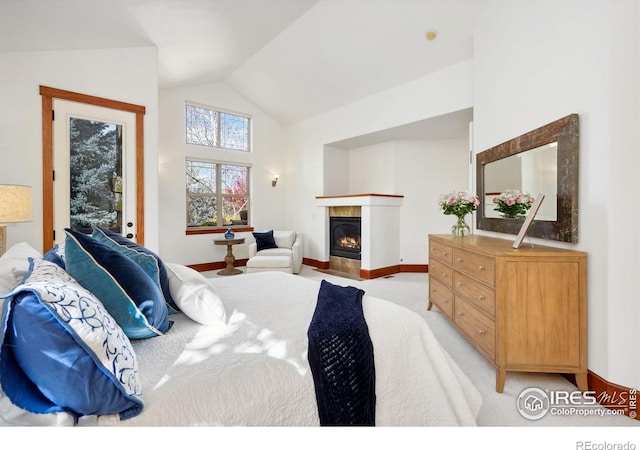 carpeted bedroom featuring access to outside, a tile fireplace, and vaulted ceiling