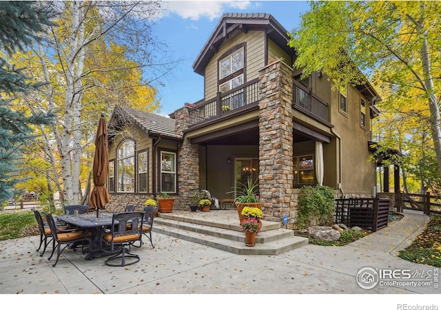 rear view of house featuring a balcony and a patio area