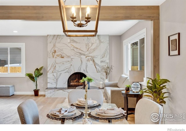 living room with hardwood / wood-style flooring, an inviting chandelier, and a premium fireplace