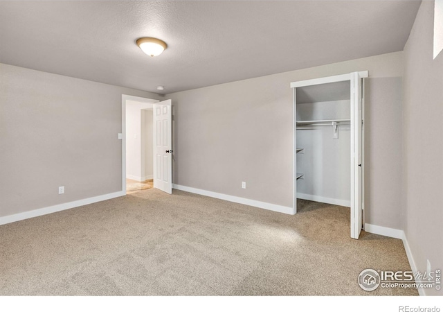 unfurnished bedroom with a closet, carpet, and a textured ceiling