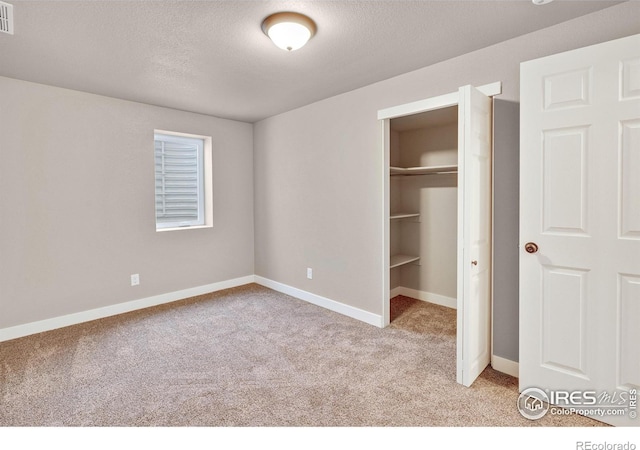 unfurnished bedroom with light carpet and a textured ceiling