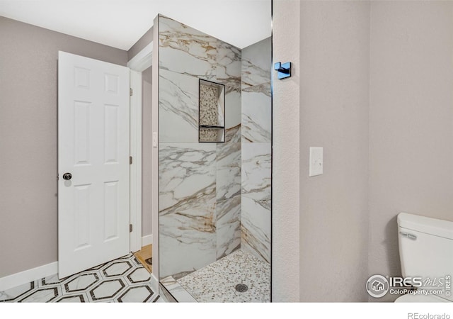 bathroom featuring tiled shower and toilet