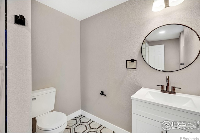 bathroom featuring tile patterned floors, vanity, and toilet