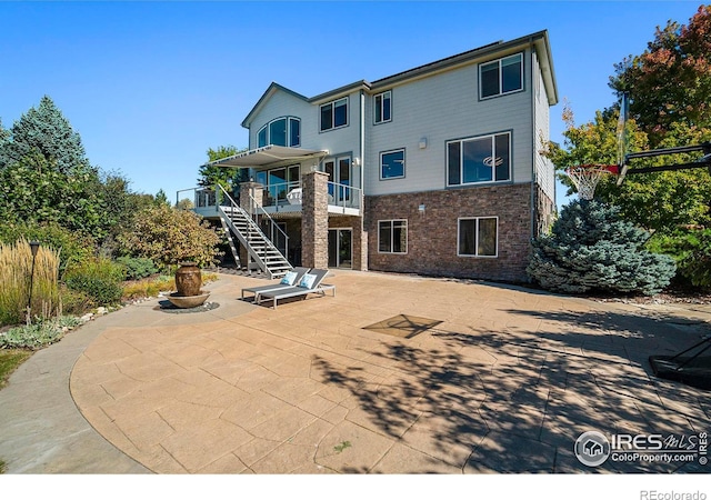 rear view of house with a balcony and a patio