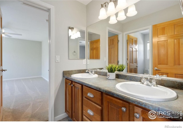 bathroom with vanity and ceiling fan with notable chandelier