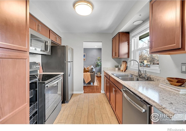 kitchen featuring light stone countertops, appliances with stainless steel finishes, and sink