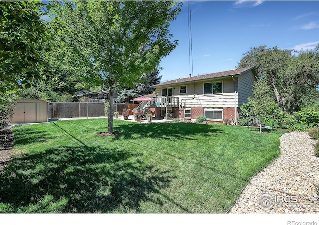 view of yard featuring a storage unit, a patio area, and a wooden deck