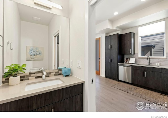 interior space with backsplash, toilet, vanity, and hardwood / wood-style flooring