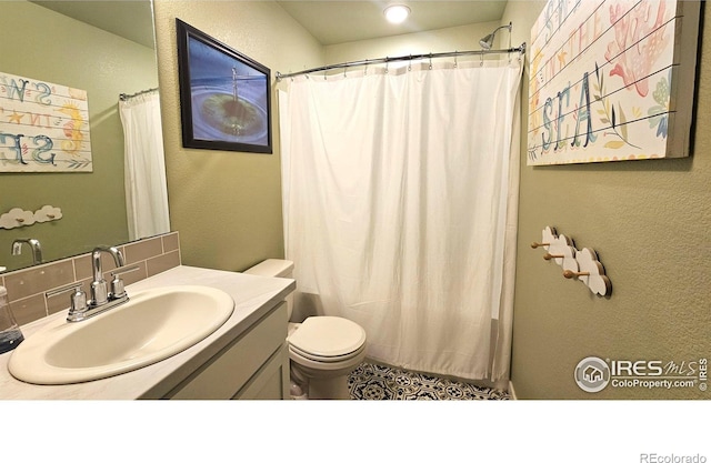 bathroom featuring a textured wall, a shower with shower curtain, vanity, and toilet