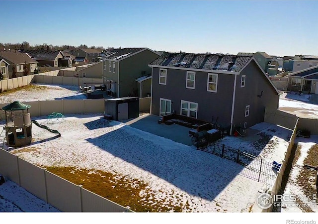 view of front of property featuring a playground, a fenced backyard, and a residential view