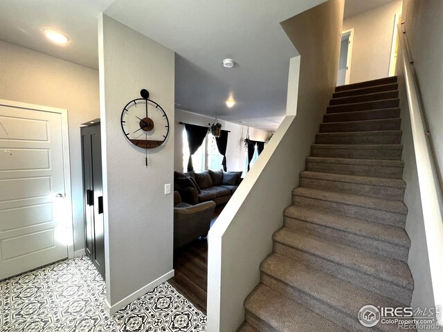 staircase featuring baseboards and wood finished floors