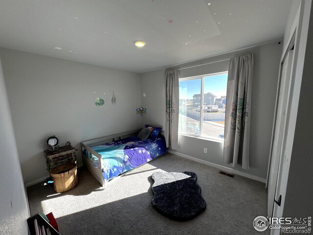 carpeted bedroom featuring visible vents and baseboards