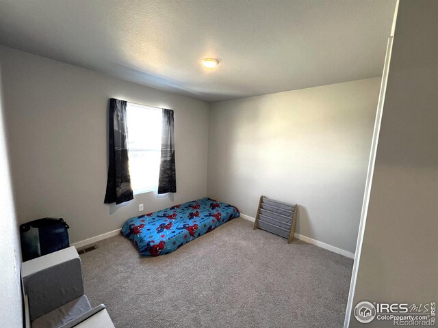 carpeted bedroom featuring baseboards and visible vents