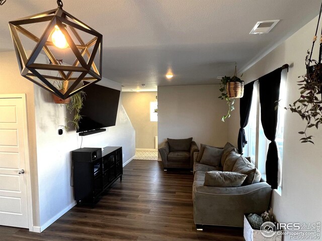 living area featuring baseboards, visible vents, and dark wood finished floors