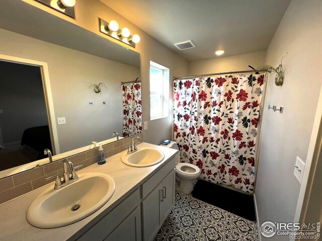 full bath with double vanity, visible vents, a sink, and ensuite bathroom