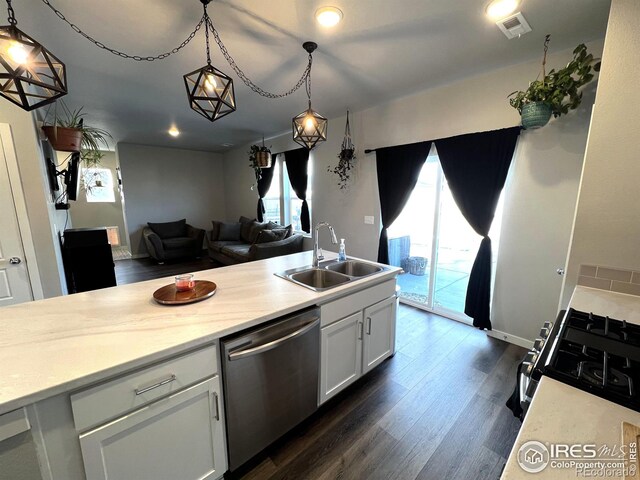 kitchen featuring a sink, white cabinets, open floor plan, dishwasher, and pendant lighting