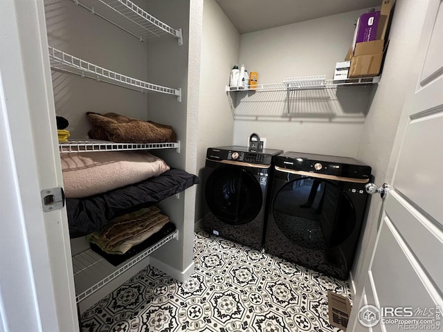 laundry room with laundry area, washer and clothes dryer, baseboards, and light tile patterned floors