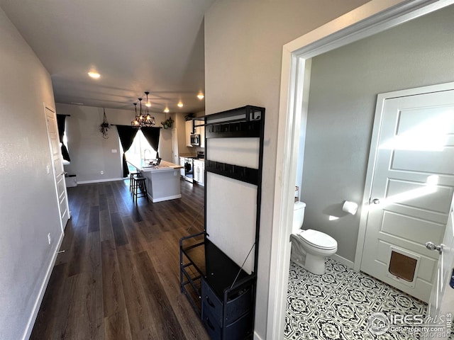 interior space featuring wood finished floors, toilet, and baseboards