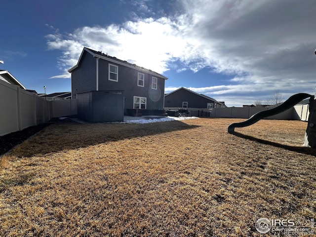 rear view of house featuring a fenced backyard