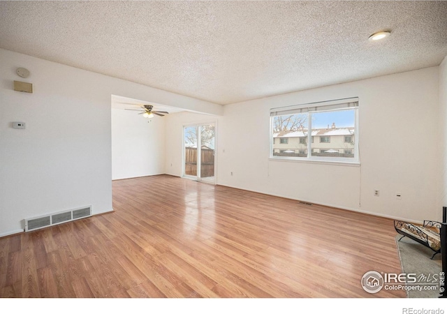 empty room featuring a textured ceiling, light hardwood / wood-style flooring, and ceiling fan