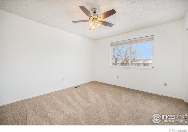 unfurnished room featuring carpet, ceiling fan, and a textured ceiling