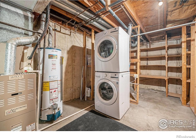 clothes washing area featuring stacked washer and dryer and gas water heater