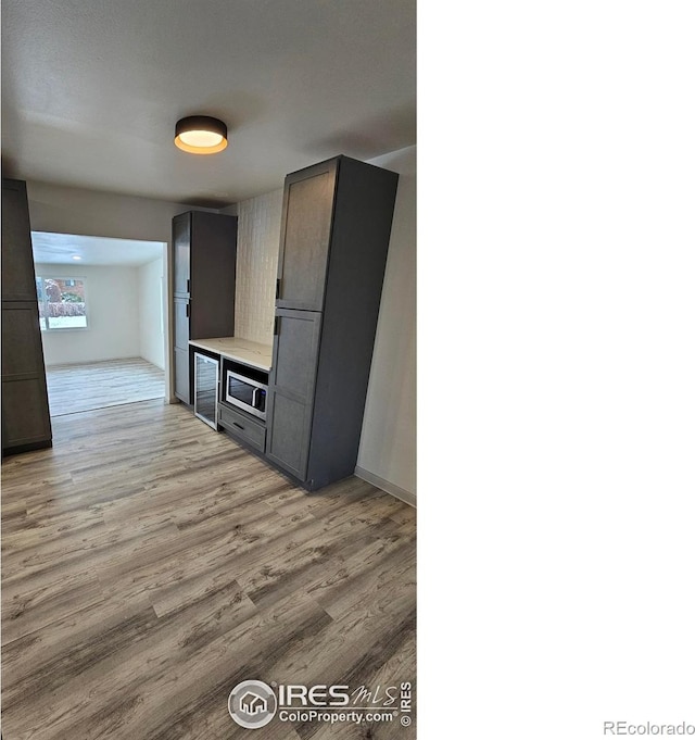 kitchen with stainless steel microwave and light wood-type flooring