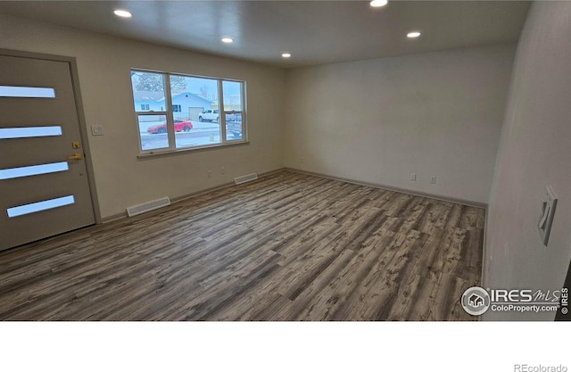 empty room with dark hardwood / wood-style flooring