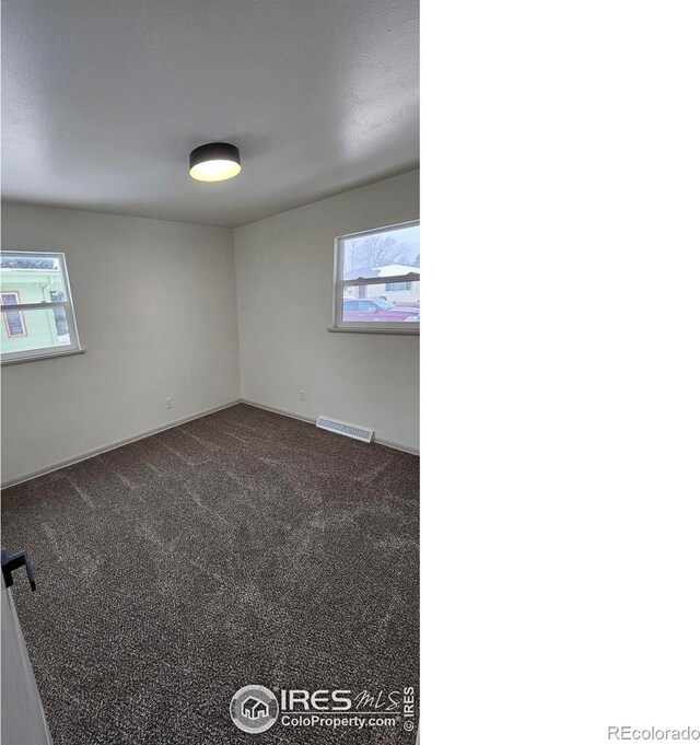 empty room featuring dark colored carpet